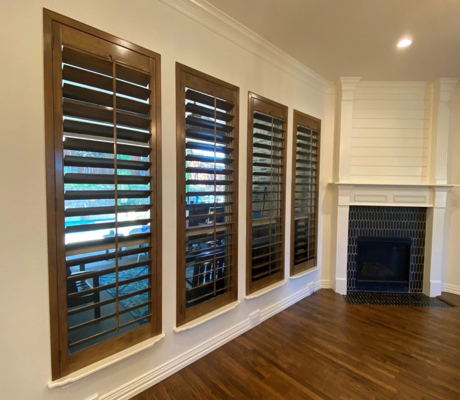 Dark wood shutters beside a fireplace mantle