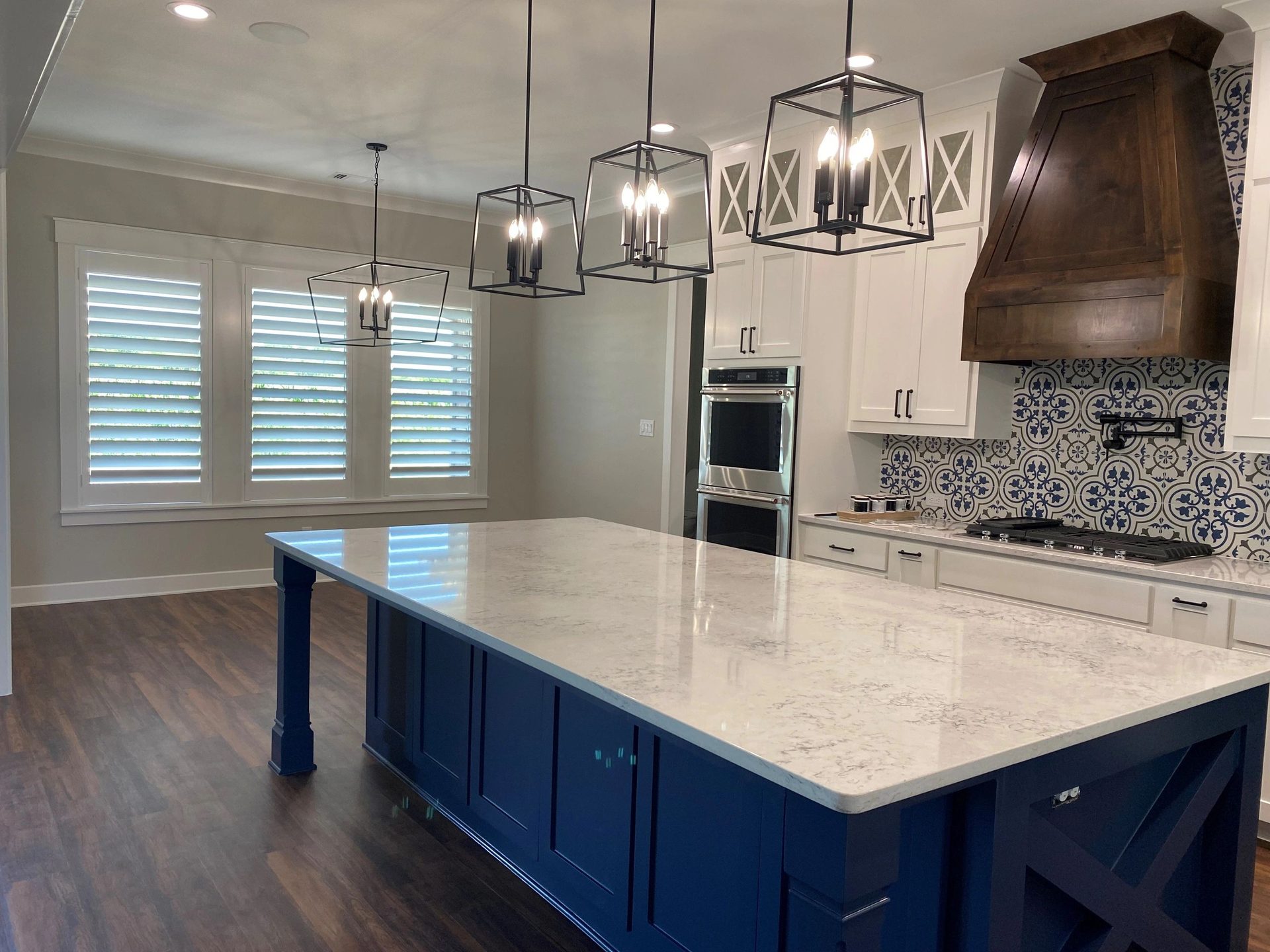 Kitchen with navy blue island and custom shutters